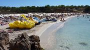 Vista de la zona de arena en Cala Saona, tumbonas  y sombrillas