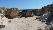 Zona de roca y arena en la costa de Es Carnatge en Formentera