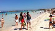 La playa llena de gente con agua cristalina