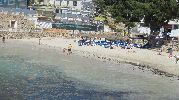 personas jugando en la playa y otras tomando el sol