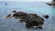 rocas en el mar  y un barco en mar abierto