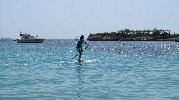 surfista en el agua y barco al fondo