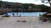 playa con hamacas, sombrillas y boyas para barcos en el agua