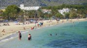 playa con sombrillas, hamacas y puesto de socorrismo