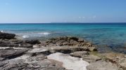 playa muy rocosa con agua azul verdoso