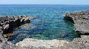 playa muy pequea, rocosa y con el agua muy clara