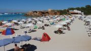 Cinco filas de sombrillas en Cala Saona y restaurante al fondo