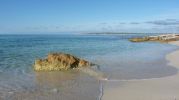 Orilla de playa Es Valencians y vistas al Cap de Babaria en Formentera
