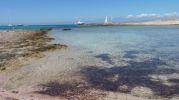 Zona izquierda de la playa rocosa y arenosa