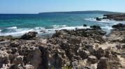 Zona de rocas en la platja d'es Carnatge con vistas a La Mola