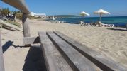 Primer tramo de la playa Es Ca Mar con el gran hotel al fondo y las casetas varadero