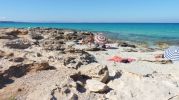 Turistas tomando el sol en zonas rocosas