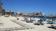 playa grande con sombrillas, hamacas y caminos de madera