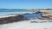 Pequea embarcacin en un extremo de la playa de Es Peregons Grans