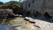 antiguo muro de piedra roto, al parecer, por las olas