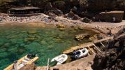 agua muy clara y grandes rocas en el fondo